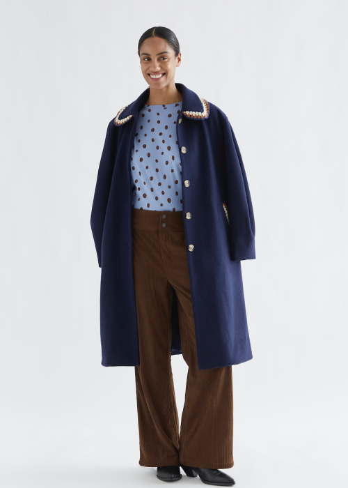 Compania Fantastica Navy Blue Long Coat with Decorative Crochet Collar, Light Blue Polka Dot Top and Brown Wide-Leg Corduroy Trousers